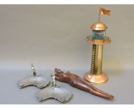 A pair of 'Australia' shaped ashtrays, with kangaroo handles, a copper lighthouse lamp, and a wooden female figure nut cracke