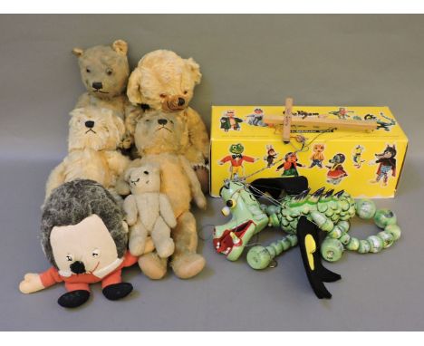 A collection of vintage teddy bears, including Merrythough, and a Pelham puppet of a dragon
