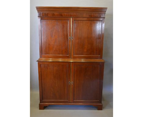 A 19th Century Mahogany Press Cupboard the moulded cornice above four panel doors, raised upon bracket feet, 114cm wide, 53cm