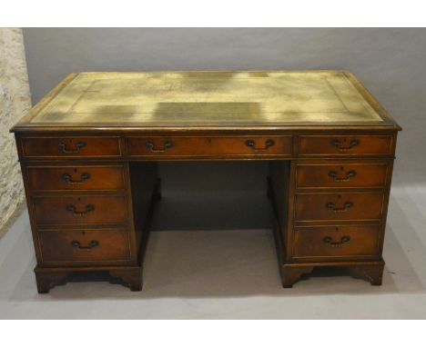 An Early 20th Century Mahogany Twin Pedestal Desk, the green tooled leather inset top above nine drawers with brass handles, 