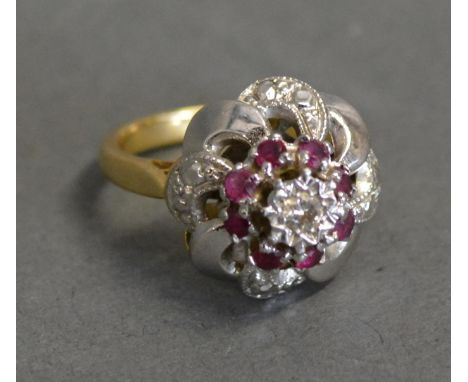 A Diamond And Ruby Cluster Ring With A Central Diamond surrounded by rubies within a pierced setting 