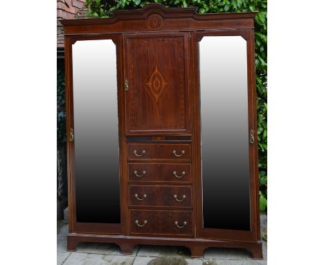 An Edwardian Mahogany Marquetry Inlaid Wardrobe the shaped moulded cornice above a central door and four drawers with brass h