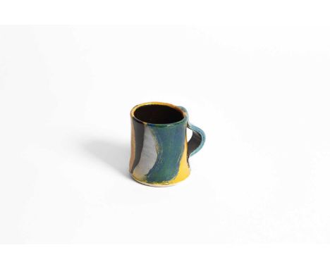 ARR John Pollex (born 1941), a slipware mug decorated blue, black and yellow glaze, impressed JP mark, 9cm highIn good condit