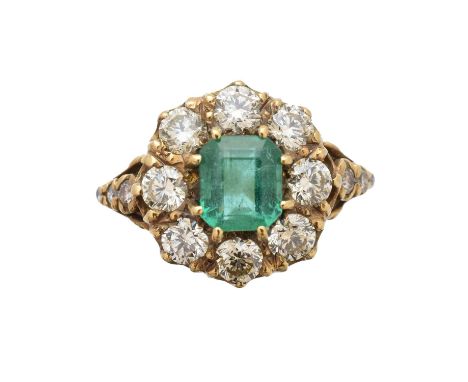 An emerald and diamond cluster ring, the rectangular shape emerald within a brilliant-cut diamond surround and similarly cut 