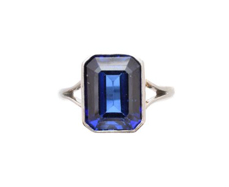 A synthetic sapphire single stone ring, the rectangular shape synthetic sapphire with tapered shoulders, stamped Platinum, ri