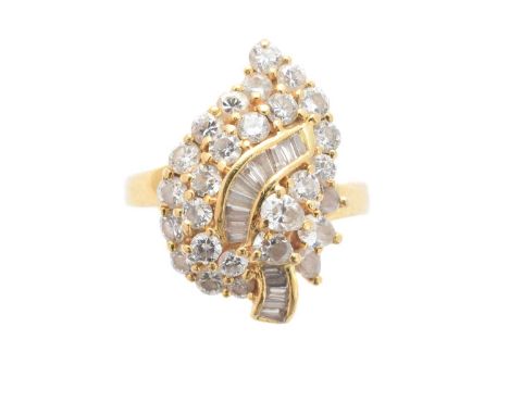 A diamond cluster ring, of asymmetric design, the brilliant cut and pear shape diamond cluster with a baguette cut diamond sc