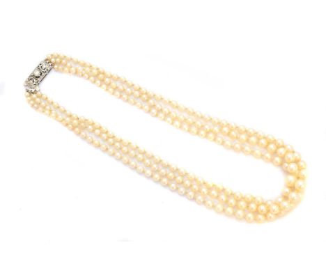 A cultured pearl and diamond necklace, the triple row of graduated cultured pearls with a brilliant cut diamond foliate push-