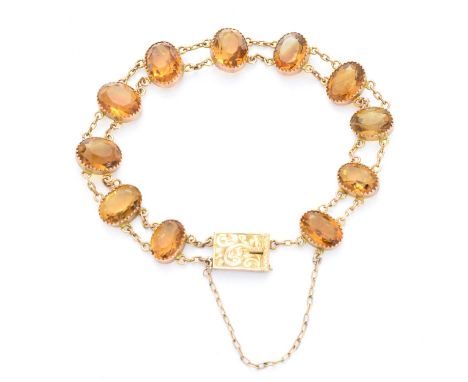 An early 20th century citrine bracelet, designed as a series of oval shape citrine collets, with double trace-link chain spac