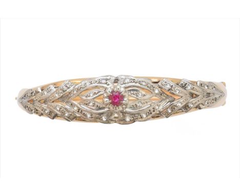 A ruby and diamond hinged bangle, the circular shape ruby within a single cut diamond openwork surround, with plain polished 
