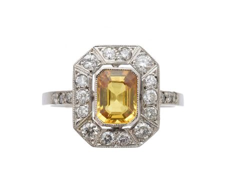 A sapphire and diamond cluster ring, the rectangular shape yellow sapphire within a brilliant-cut diamond surround and simila