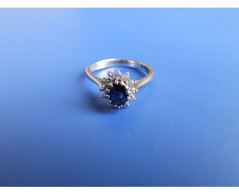 A small modern oval sapphire &amp; diamond cluster ring in 18ct white gold. Finger size K/L.