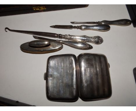 A Birmingham silver cigarette case, a silver-handled button hook, four silver handled manicure items and a quantity of small 