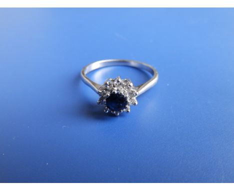 A small modern sapphire &amp; diamond circular cluster ring set in 18ct white gold.  Finger size R.