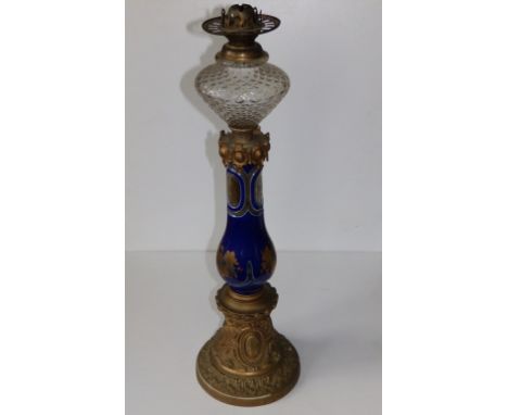 A tall 19thC blue glass oil lamp with engraved decoration to the glass column and (rubbed) gilding, moulded glass font, 25" h
