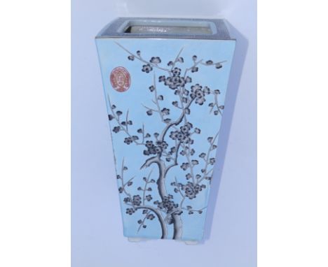 A Chinese Qing Dynasty porcelain tapering square section vase, decorated in a 'four flowers' pattern on pale blue ground, two