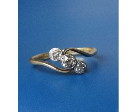 An old cut three stone diamond crossover set ring in 18ct gold &amp; platinum.  Finger size R.