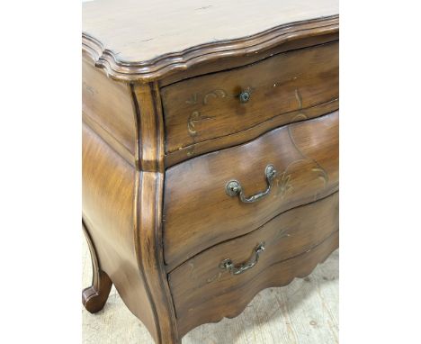 A reproduction Italian style painted finish bombe commode with painted floral swag decoration, with shaped apron, on scrolled