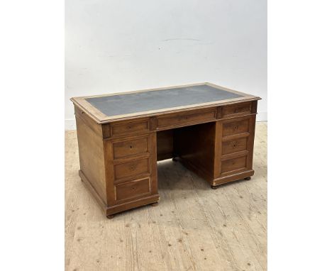 An Edwardian light mahogany twin pedestal desk with leather skiver and centre drawer, with banks of four short drawers, slide