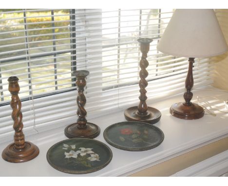 An oak barleytwist candlestick, c.1930;  others;  side lights;   two circular  wooden plates, painted with stylised flowers (