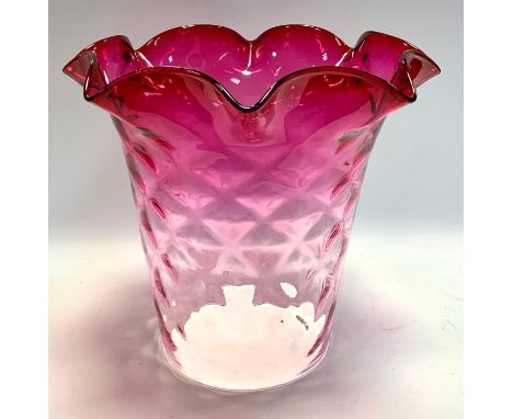 An Early 20th century cranberry glass lamp shade, tapering crosshatched body, wavy rim, front 26cm diameter, rear 13cm diamet