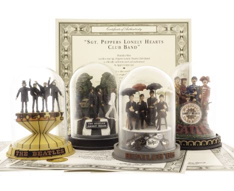 The Beatles: six Franklin Mint hand crafted figurines in crystal glass domes, sold with wooden display shelf, each with a cer