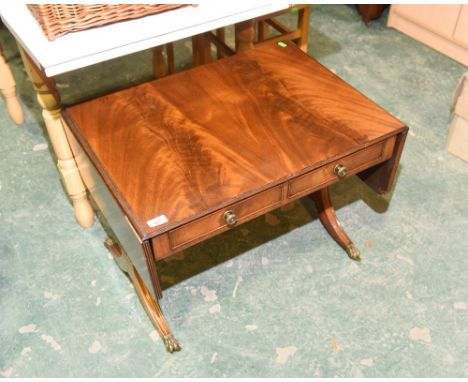 A 19th century drop leaf sofa table with brass claw feet moving on castor