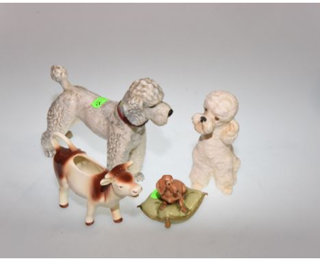 W. Goebel figure of a Poodle, together with porcelain figure of a dachshund seated on a cushion, a Goebel china novelty cow c