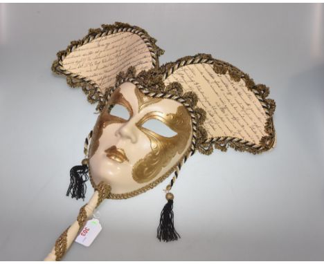 A lady's Venetian gold and cream painted full-face mask with stick, applied with gilt thread decoration