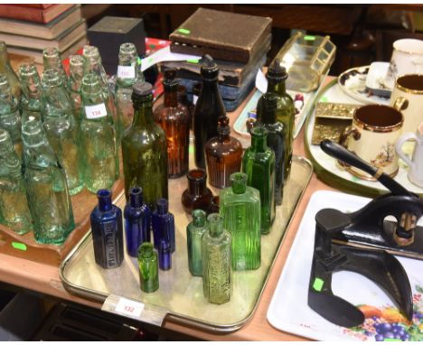 A tray of vintage apothecary bottles inc. green brown and blue glass. Examples inc. E Harper, R Stothert & Sons poison, Benbo