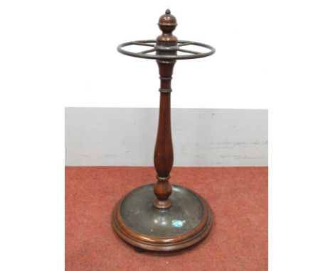 A Mahogany Stick Stand, with turned finial, bronzed circular rail on turned stand and circular base with drip tray, on bun fe