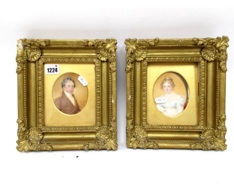 A Pair of Early XIX Century Portrait Miniatures, painted on ivory, with a lady and a gentleman head and shoulders, she wearin