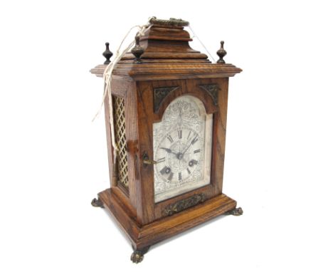 A XIX Century Oak Cased Bracket Clock, with caddy top, bronzed finials, glazed door to silvered dial with Roman numerals, on 