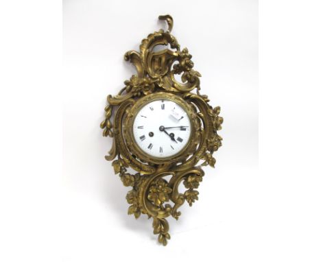 A XIX Century French Wall Clock, in gilt metal case, cast with flowers and scroll work, circular white enamel dial with black