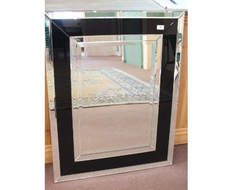 A contemporary rectangular bevelled edge mirror with black glass surround