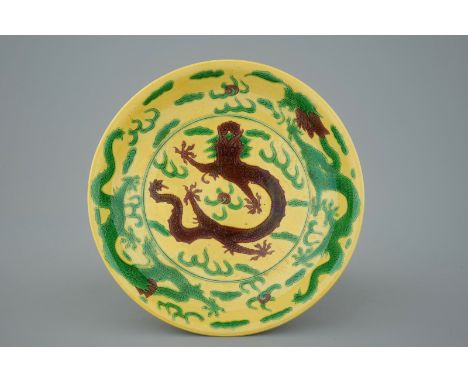 A Chinese yellow-ground green and aubergine enameled dragon dish, Kangxi mark, 19th C.  Dia.: 26 cm - H.: 4,5 cm  Condition r