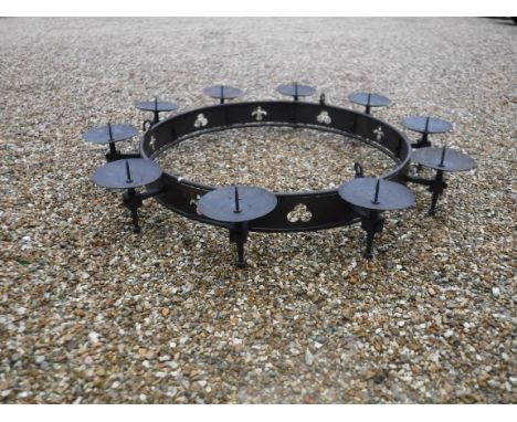 A modern wrought iron hanging ceiling light in the Gothic style with ten pricket candle holders above a pierced banded framew