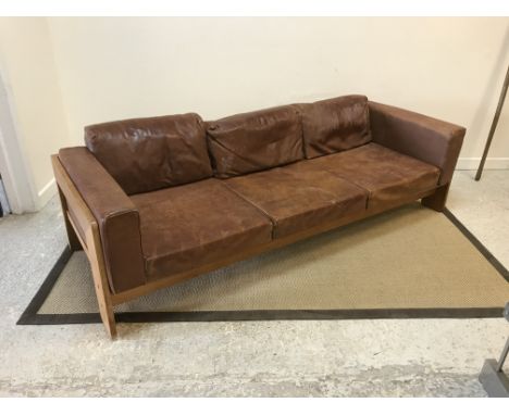 A mid 20th Century oak framed brown leather upholstered three seat sofa in the Scandinavian taste, 211 cm wide x 76 cm deep x