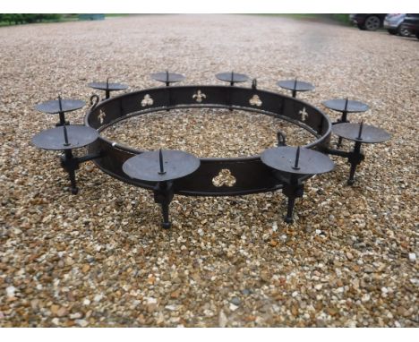 A modern wrought iron hanging ceiling light in the Gothic style with ten pricket candle holders above a pierced banded framew