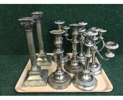 Two trays of plated four piece tea services, candlesticks, plated candelabra, etc 