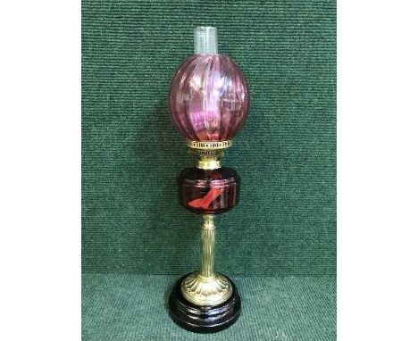 A brass and cranberry glass oil lamp 