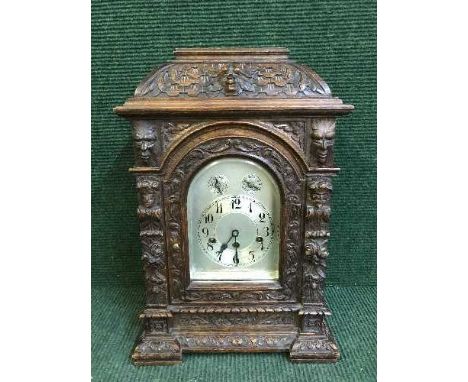 A carved oak chiming bracket clock with silvered dial 