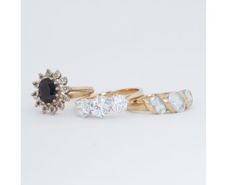 Three 9ct yellow gold rings to include a sapphire cluster ring, three stone crystal set ring &amp; a three stone aquamarine r