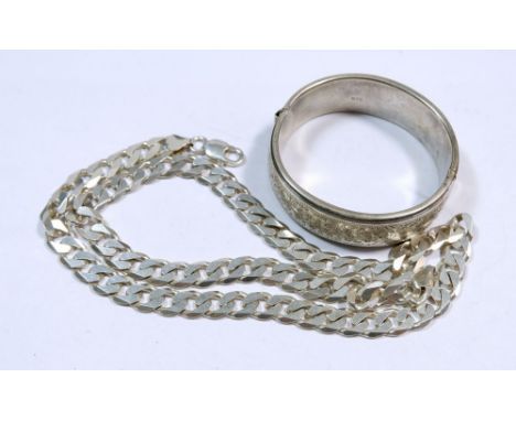 A silver curb link necklace, 62g, 56cm and a silver engraved bangle, 91g 