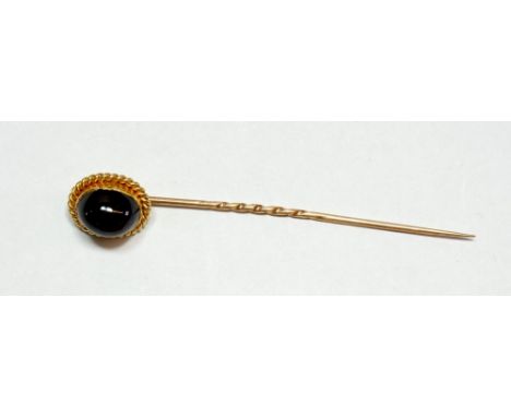 A yellow metal stick pin set cabochon garnet 