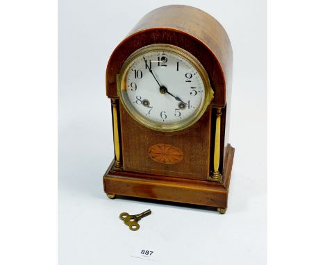 An Edwardian mahogany arch top clock with paterae inlay and brass columns, 27cm tall 