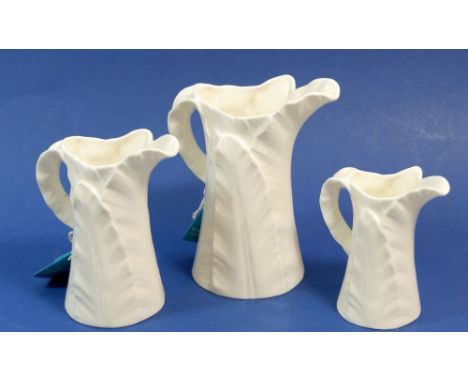 Three Royal Worcester white leaf graduated jugs, tallest 15cm 