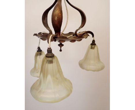 A pair of Edwardian Art Nouveau beaten copper three branch light fittings in the style of Benson, one fitted three vaseline g