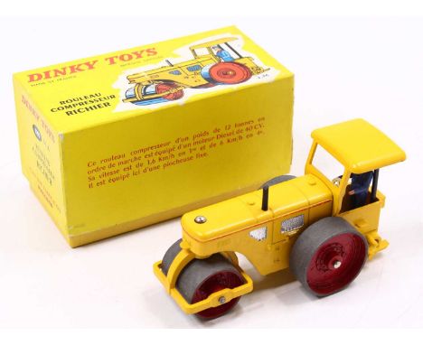 A French Dinky Toys No.830 Richier Road Roller in yellow body with red inside rollers with driver and original card No. 830 b