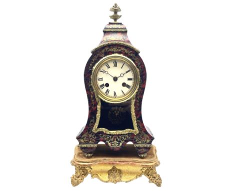 19th century brass inlaid red Boulle work mantel clock on ornate gilt stand, cartouche shaped case with floral urn finial, ci