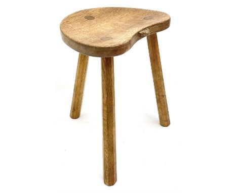 'Mouseman' oak three legged stool with dished kidney shaped seat, tapered octagonal supports, with carved mouse signature, by